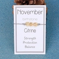 Detail view of November birthstone bracelet featuring raw Citrine stones on grey woven cord - November/Citrine