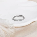 Macro shot of silver micro-pave cubic zirconia band on a white shell and silk backdrop - US 5 / Silver