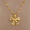 Macro detail of gold-plated hollow bow pendant featuring sparkling zircon stones - Bowknot Necklace (D129 Necklace)