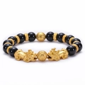 Dettaglio delle perle di onice nera e del ciondolo dorato Pi Xiu sul braccialetto - Bracciale PiXiu In Agata Nera Naturale 10MM