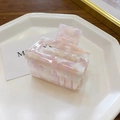 Detail of pink marble textured acetate hair claw clip on a white octagonal tray - Small / Pink