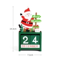 Close-up of wooden Christmas advent calendar with Santa, tree, and blocks showing December 24 - Santa Claus / Green