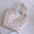 Détail d'un sac à main en toile fleurie avec étiquette décorative sur tissu blanc - Base Blanche Fleur Rose Clair