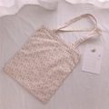 Gros plan sur un sac cabas en coton à fleurs avec un motif vintage sur fond crème - Blanc Rose Fleuri