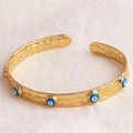 Bracciale rigido aperto placcato oro 18K con texture e ciondoli occhio blu - Celeste