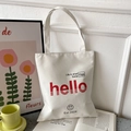 Detailed view of white canvas tote bag with red Hello print and smile face design - White with Hello Smile Print