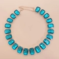 Detailed close-up of aquamarine rectangular crystal necklace on a soft pink background - Lake Blue