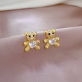 Macro detail of gold teddy bear earrings with heart-shaped zircon on silk fabric - Teddy Bear Heart Stud Earrings (D228)