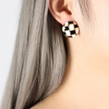 Checkered pattern round earrings with gold trim worn by a model in a close-up view - Gold Round (F759)