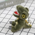 Gros plan d'un porte-clés dinosaure en peluche verte avec anneau en métal sur tissu - 14 cm (avec chaîne de perles) / vert foncé