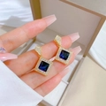 Vista macro di orecchini geometrici blu con scintillanti cristalli micro-pavé e oro lucido - Orecchini a Bottone Quadrati Blu (G208)