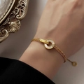 Golden double-chain bracelet with white shell circle and BELOVE engraving - Gold Bracelet With Circular White Mother of Pearl and Rhinestone