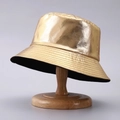 Dettaglio cappello alla pescatora in pelle PU oro metallizzato su supporto di legno - Taglia unica / Oro