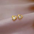 Macro view of gold-tone heart stud earrings with sparkling white crystals on purple silk - Titanium Steel Style / Gold