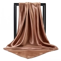 Detailed view of glossy bronze satin square scarf draped over a black display frame - Dark Camel