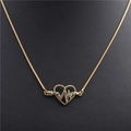Detail van gouden hartvormige ketting met gekleurde zirkoon-inleg op zwarte achtergrond - Hartslag Hart Goud / Goud