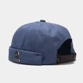 Detail of navy blue herringbone docker hat with metal leaf badge and leather strap - Mist Blue With Letter Maple