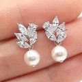 Orecchini a foglia in argento con zirconi AAA e perla bianca tenuti in mano - Oro Bianco
