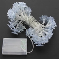 Solar powered lotus flower LED string lights with transparent battery box on black background - White