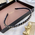 Elegant thin gold headband with dark blue and gold beads on a brown jewelry display - Twisted Blue