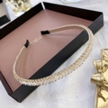 Detailed shot of a gold metal headband with sparkling clear crystals in a display tray - Plain White