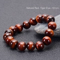 Macro detail of 12mm natural red tiger eye beads with silk luster and cat-eye effect - 12mm