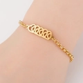 Detail of a gold titanium steel bracelet featuring hollow heart charms on a female wrist - 5 Hearts / Gold