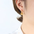 Eleganti orecchini a doppio anello dorati con micro-intarsio indossati su una modella - Oro