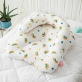 Infant baby nest bed with colorful rainbow and stars print on a white quilted surface - Rainbow