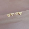 Elegant gold bow earrings with pavé crystals on purple velvet background flat lay view - Full Diamond Bow Style (A109)
