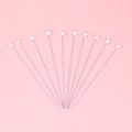 Set of 12 white star-shaped cake toppers with slender silver sticks on pink background - Small White Star - 10 Pack