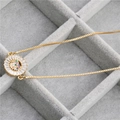 Detailopname van de vergulde zonne-hanger met gekleurde zirkoon in een fluwelen doos - Cirkel Hart Goud / Goud