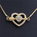 Primer plano del colgante de corazón dorado con circonitas de colores y flecha en cuero - Flecha Dorada a Través del Corazón con Circón Multicolor