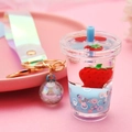 Close-up of strawberry milk tea keychain with flowing glitter and iridescent strap - Strap Clasp + Milk Tea Cup + Bead / Light Blue