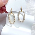 Elegante gouden ovale pareloorbellen met kristallen op een witte kaartdisplay - Goud Ovaal Parel Strass