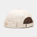Detail of beige brimless docker cap with golden leaf pin and adjustable metal buckle - Beige With Metal Maple