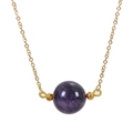Macro shot of 16mm purple amethyst bead pendant on golden chain with vintage details - Purple