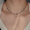 Detail of beaded choker featuring gold, black, and tea-colored faceted crystals on model - Black