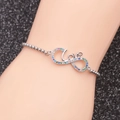Detailed view of silver infinity Love bracelet with colorful rhinestones on a model wrist - LOVE Infinity / Silver/Rainbow Zirconia