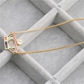 Dettaglio del ciondolo a corona dorata con zirconi colorati su una catena a box - Corona A (Pietra Multicolore) / Oro