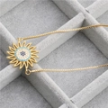 Goldene Halskette mit Zirkonia-Sonnenblumen-Anhänger auf einem grauen Samt-Tablett - Sonnenblume B / Gold