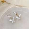 Golden double butterfly earrings with white enamel finish on a luxury silk tray - Gold Double Butterfly