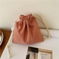 Close-up of brick red linen drawstring storage bag with dual-cord closure and textured fabric - Small / Orange Pink