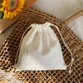 Minimalist cream cotton drawstring storage bag on a natural woven mat with sunflowers - Small / White