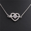 Primer plano de pulsera plateada con colgante de corazón de circonitas de colores y flecha - Flecha de Platino Bañada a Través del Corazón con Circón Multicolor