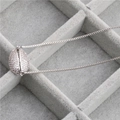 Elegante collar de cobre con colgante de concha y circonitas en una caja de joyería gris - Platino Circonita Blanca Concha