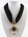 Detail of a large gold concentric ring pendant with black stone on a fabric necklace - Black