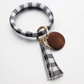 Close-up of black and white plaid leather bangle keychain with matching tassel and wood pendant - Black White Grid