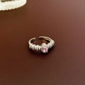Detail van roze ovale zirkoon ring met micro-pave op een lederen achtergrond - Ring - Roze Ovaal