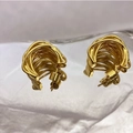 Dettaglio di orecchini a cerchio intrecciati dorati con perni in argento 925 - Placcato Oro Vero / Oro